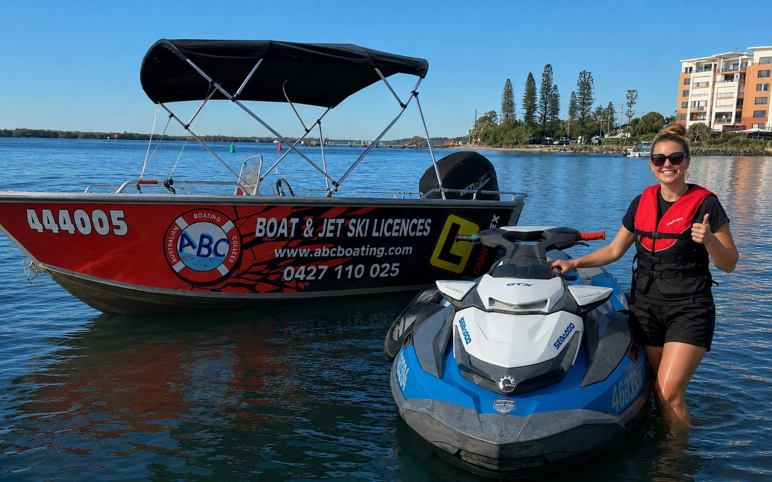 A student beside a Sea-Doo jet ski with the ABC Boating training boat alongside, the two vessels used on the combined boat and jet ski licence day
