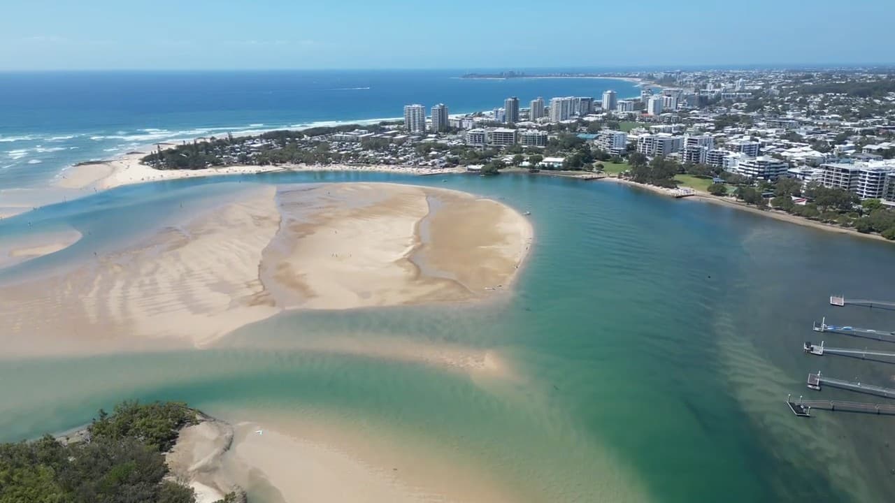 Aerial view over the Maroochy River mouth at Maroochydore, with the sandbar, the river channel and the Sunshine Coast skyline behind