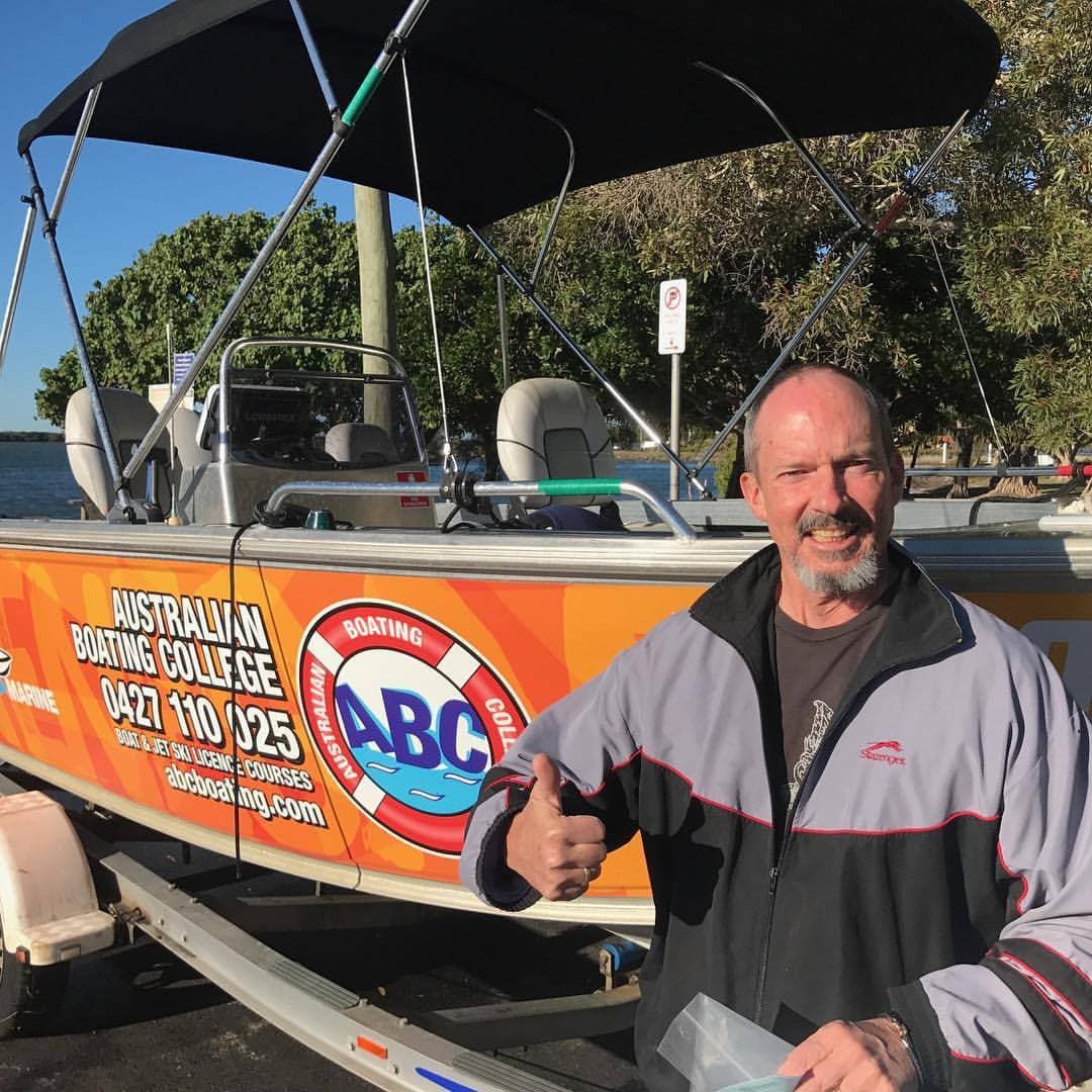 An ABC Boating instructor beside the branded training boat on the Sunshine Coast